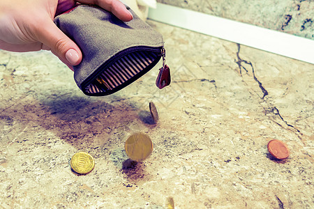 几个硬币从一个女人手中的空钱包里掉下来预算银行债务金融危机货币贫困支付金子金属图片