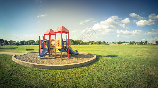 游乐场儿童美国得克萨斯州阳光明媚日绿公园的全景公共儿童游乐场闲暇天空草地力量孩子公园学校运动玩具童年背景