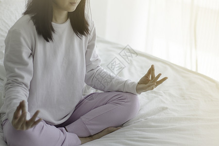 瑜伽室女人坐在床垫上的瑜伽上冥想疼痛身体运动女孩女性头脑女士姿势唤醒背景