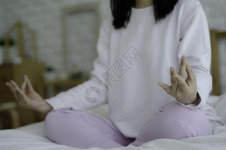 女人坐在床垫上的瑜伽上女性姿势房间冥想唤醒运动身体疼痛女孩头脑图片