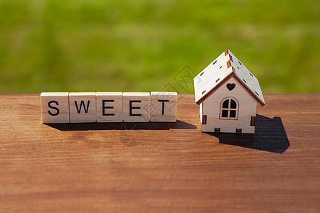 甜言蜜语的木信和棕色的小玩具木屋图片