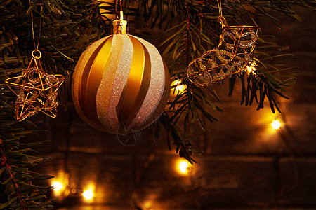 圣诞树枝上的圣诞成份 舞会和其他装饰品 在黑暗背景和有灯光的暗幕下辉光火花花环风格庆典松树卡片星星装饰珠子图片