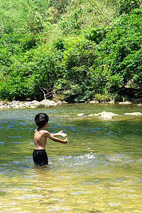 在河里玩水的亚裔男孩图片