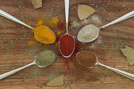 在勺子上安排各种彩色调味品桌子辣椒草本植物味道金属粉末香气芳香美食香料图片