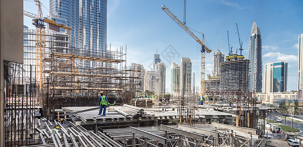 在迪拜从事现代同心合力工地工作的劳工在城市快速发展公司工作团队劳动工程师工作服水泥建筑学工程头盔劳动者安装图片