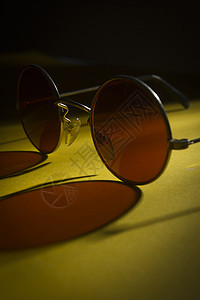黄色表面的圆太阳镜潮人反射桌子眼镜框架阴影镜片圆形黑色图片