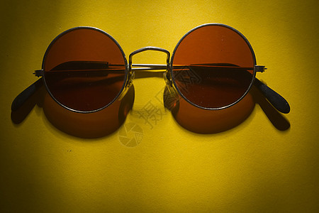 黄色表面的圆太阳镜潮人圆形框架镜片黑色桌子眼镜阴影反射图片