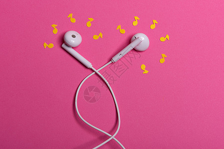 粉红色背景上的白色耳机和黄色纸币 从上面看配饰水平电话娱乐金属技术工作室粉色创造力立体声图片