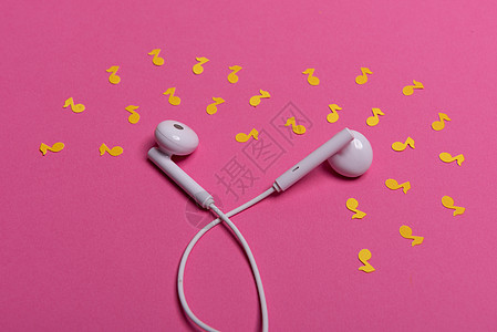 粉红色背景上的白色耳机和黄色纸币 从上面看电缆配饰耳朵立体声创造力粉色文化水平电子工作室图片