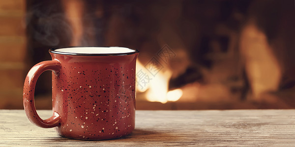 在燃烧的壁炉 舒适 冬季假期和温暖的心房概念面前 红杯加热茶图片