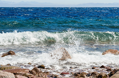 以吉海岸的海浪 海浪和石块喷洒异国海水天堂山脉蓝色旅行波浪泡沫石头假期图片