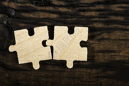 在深色背景上的木制拼图团队玩具团体白色商业合伙解决方案战略成功游戏背景图片