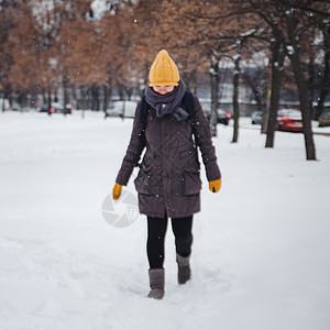 穿着黄毛帽和背包手套的年轻欧洲女子在雪瀑下欢笑 反向效应 模糊不清喜悦微笑天气毛衣雪花乐趣头发自由降雪快乐图片