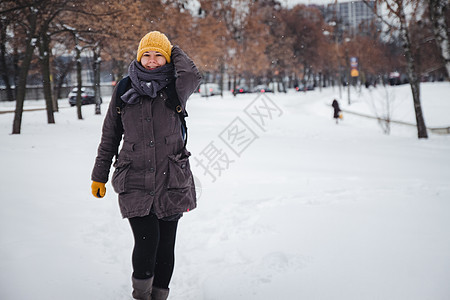 穿着黄毛帽和背包手套的年轻欧洲女子在雪瀑下欢笑 反向效应 模糊不清女士女性自由帽子雪花幸福喜悦天气乐趣快乐图片