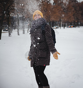 穿着黄毛帽和背包手套的年轻欧洲女子在雪瀑下欢笑 反向效应 模糊不清天气自由雪花享受乐趣头发毛衣微笑眼睛青少年图片