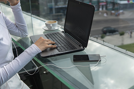 一位女士正在使用桌上的笔记本电脑工作 手在键盘上打字 女商务人士坐在咖啡馆的笔记本电脑键盘上打字店铺教育桌面办公室屏幕电话咖啡技图片