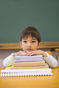 快乐的学生在书桌上靠书本课堂男性知识小学生倾斜瞳孔黑板班级早教教育图片