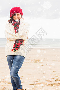 在沙滩上穿着时尚温暖衣着的可爱笑容女性综合形象图片