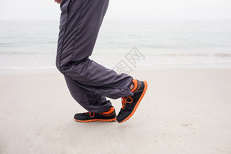 老年跑步人在沙滩上慢跑时走路背景