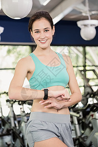 使用智能手表的妇女闲暇触摸屏电脑运动服锻炼女性健身室训练微笑体质图片