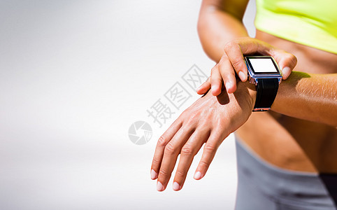 身戴连线手表的女运动员被紧贴上综合图像手腕女性设备白色移动女士跑表电脑灰色技术图片