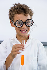 在实验室用液体装有测试管的可爱男孩图片