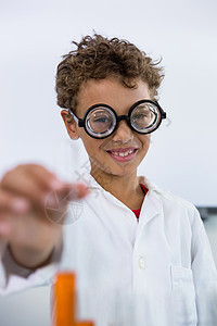 在实验室用液体显示测试管的男孩图片