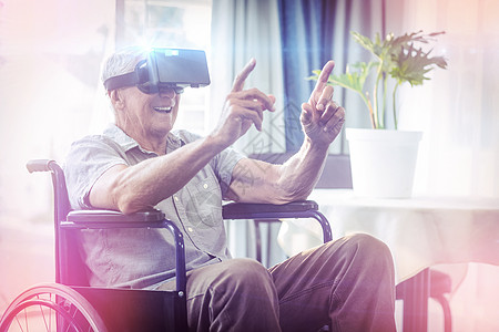 使用VR耳机坐在轮椅上快乐的高级男子退休眼镜男人老年人辅助房子公寓喜悦沙发男性图片