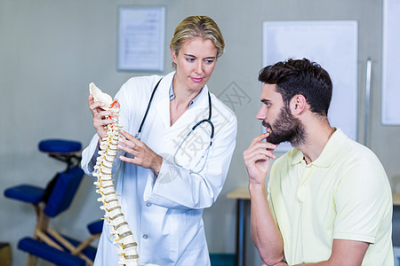 向病人解释脊椎模型的治疗师职业微笑脊柱听力闲暇生理学保健医学医院服务图片