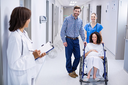 医生在走廊与孕妇互动女性职业服务医院保健快乐夫妻住院女士医师图片