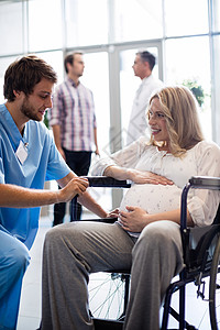 男医生与轮轮椅孕妇交谈的男医生男性沟通互动磨砂膏轮椅职业放射科药品孕产工作图片