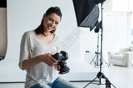 持有数码相机的女性摄影女摄影师的肖像图片