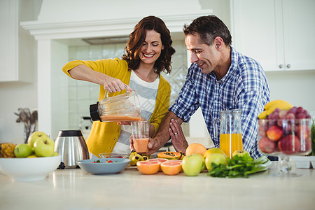 幸福的一对夫妇在厨房准备冰沙司房子木瓜香蕉夫妻帮助冰沙家庭生活食物公寓台面图片