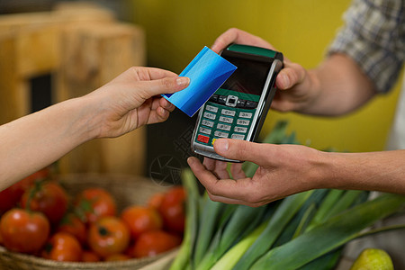 妇女在杂货店使用NFC技术付款妇女利用NFC技术付款支付团队近场市场零售服务快乐设备店铺通信图片