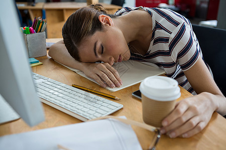 睡在办公桌边的 工作过重的图形设计师休闲商业手机职场咖啡睡眠生活电脑现实键盘图片