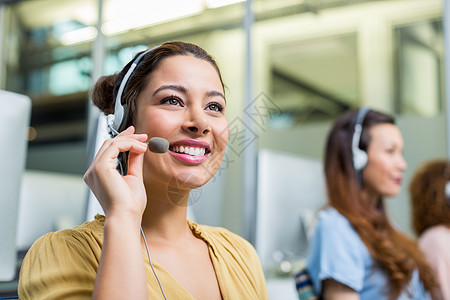 微笑女性客户服务执行官在办公桌头盔上交谈呼叫公司快乐讨论操作员休闲工作职场女士商业图片
