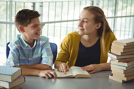 在学校图书馆读书的小学生微笑学校儿童文学男生男性学生女孩图书馆青年教科书学习互动图片