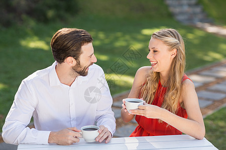 快乐的一对夫妇喝咖啡女性朋友友谊微笑桌子晴天服装情人咖啡杯亲密感图片