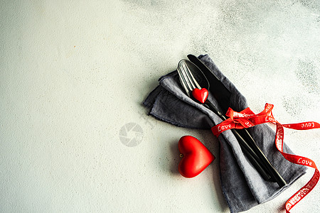 情人节圣节概念丝带刀具夫妻心形乡村风格金属餐巾红色桌子背景图片