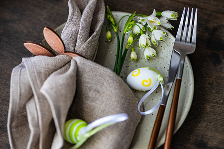 复活节晚宴的餐桌设置陶瓷卡片制品餐具盘子三色植物群框架服务刀具图片