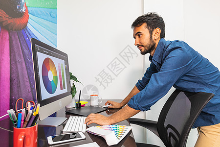 重点集中的年轻男子工作图表电脑监视器老鼠职业技术编辑艺术家桌子商业图片