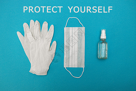 蓝色背景上的医用防护面具 手套 酒精消毒剂 上面写着保护你自己 冠状病毒感染的概念 斗争 预防 检疫 从上面看 平躺细菌科学保健图片