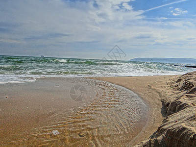 美丽的金色沙子被水晶海水淹没 云彩填满了背景图片