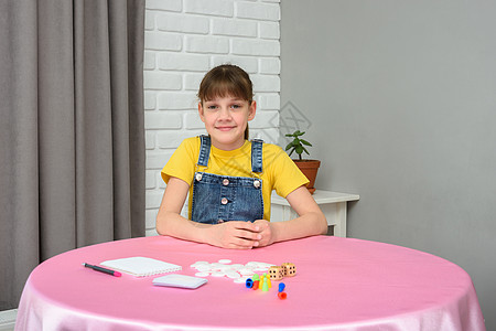 女孩坐在桌边 准备玩棋盘游戏图片