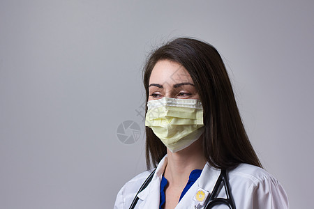 身戴灰色面罩的医务专业人员 在颈部上戴着听诊器的医生女医生保健把脉女士血压医师诊所护士护理卫生医学图片