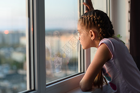在家被隔离的无聊女孩向窗外看图片