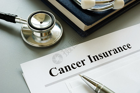 癌症保险单和书桌上的听诊器图片