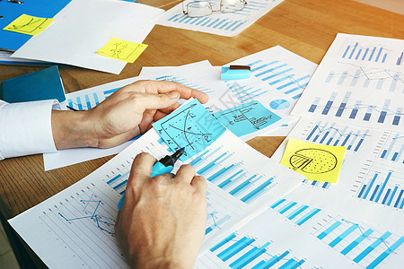 审计人正在用图表和业务图表核对财务报告 以供参考图片
