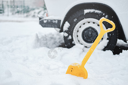 交通状况雪中的车轮和铁铲 冬季交通问题的概念背景