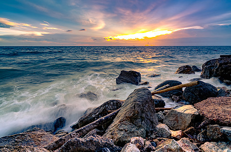 美丽的日落天空和 c 的岩石海滩上喷洒海洋水日出冲浪飞溅沿海日落海浪热带泡沫海景天空图片